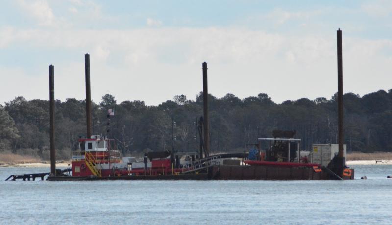 The current in Massey’s Ditch flows pretty good, so the dredging vessel is held into place by four anchor posts.